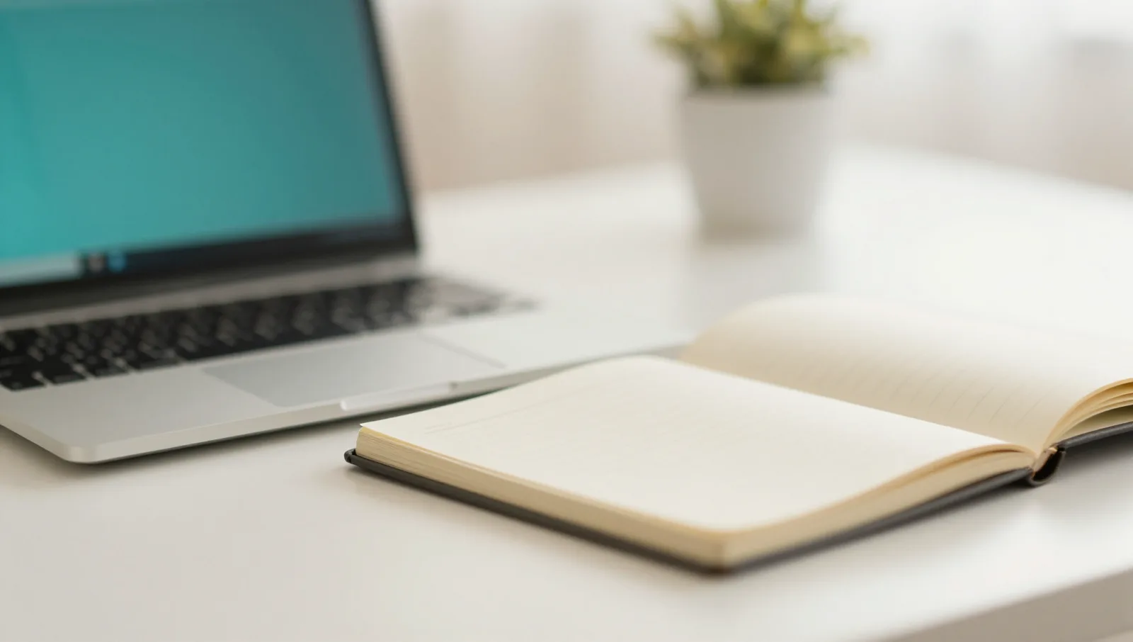 Defocused desk with a laptop and an open notebook in daylight